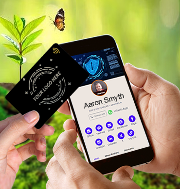A white female's hand is shown tapping an NFC card, engraved with 'Your Logo Here' and the Wi-Fi logo, onto the mobile phone held by a white man. The mobile screen displays a uBrand Hub customer's digital hub. In the background are green shrubs with a butterfly hovering over a plant. This image highlights uBrand Hub's commitment to sustainability and eco-friendliness by offering digital and NFC alternatives to paper business cards.